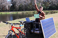 Photo of young man sitting on a solar panelled bike